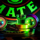 Grünes Shotglas zwischen zwei leuchtenden LED-Spinnern mit Shot-Mate-Armbändern vor Markenlogo.