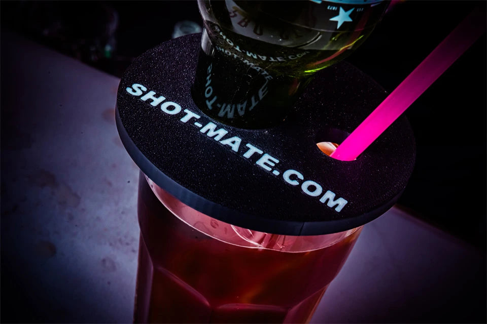 Booze Dock Aufsatz von Shot Mate mit eingesetzter Flasche und Strohhalm auf einem Getränkeglas.