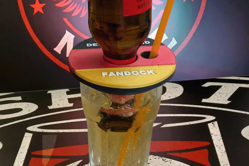 Shot-Mate Fan Dock Deutschland in Schwarz-Rot-Gold mit eingesetzter Getränkeflasche und Strohhalm. Der Getränkehalter sorgt bei Fußballpartys und Public Viewings für Ordnung und Wiedererkennung.