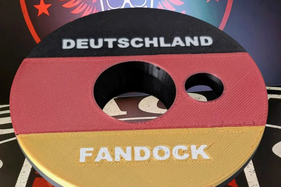 Shot-Mate Fan Dock Deutschland in den Farben Schwarz, Rot und Gold. Der Getränkehalter bietet eine Öffnung für Flaschen sowie eine separate Halterung für Strohhalme und sorgt für Ordnung bei Getränken auf Fußballpartys und Public Viewings.