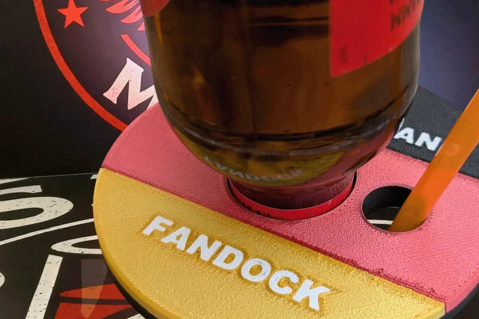 Shot-Mate Fan Dock Deutschland mit eingesetzter Getränkeflasche und Strohhalm. Der Getränkehalter in Schwarz-Rot-Gold hält Flasche und Strohhalm sicher zusammen und sorgt für Ordnung bei Fußballpartys und Public Viewings.