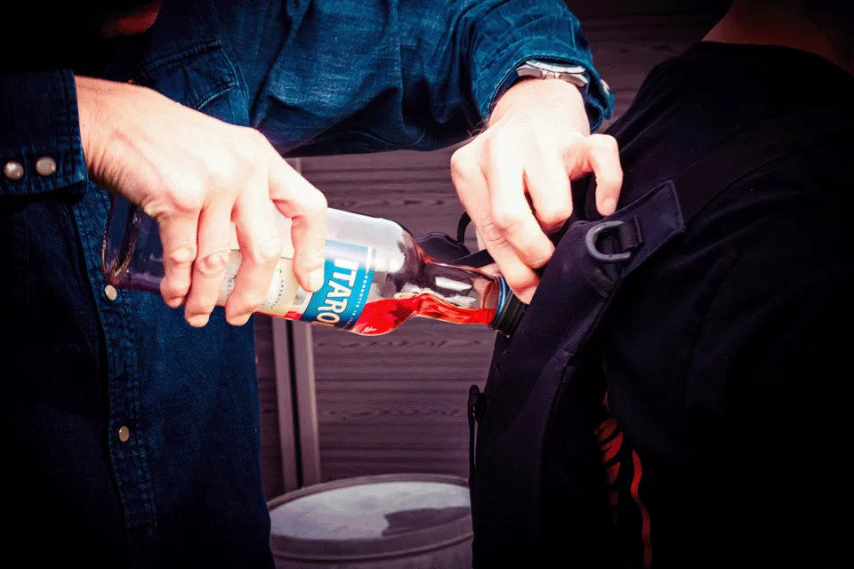 Person füllt einen Shot-Mate Getränkerucksack mit einem Getränk. Das mobile Getränkesystem kann einfach befüllt und für Partys, Festivals und Veranstaltungen genutzt werden.