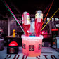 Shot-Mate Booze Pott Getränkespender mit mehreren Cocktailflaschen in einer Barumgebung. Das System eignet sich für Cocktails, Longdrinks, Partys und Veranstaltungen.